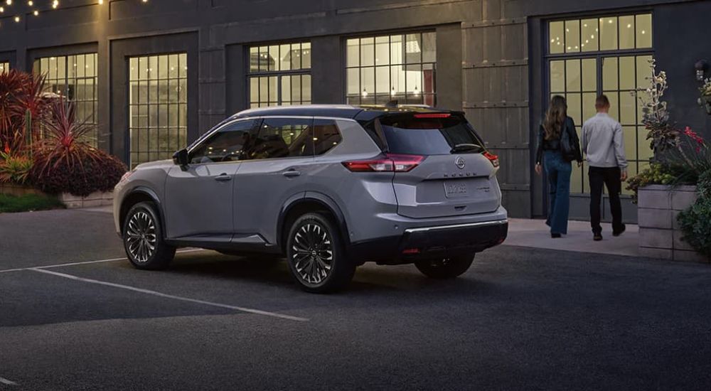 A couple is shown walking near a grey 2024 Nissan Rogue.