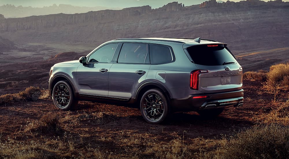 Rear view of a grey 2021 Kia Telluride parked in the desert.