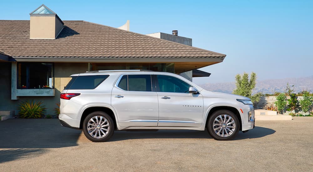 Side view of a white 2023 Chevy Traverse parked in a driveway.