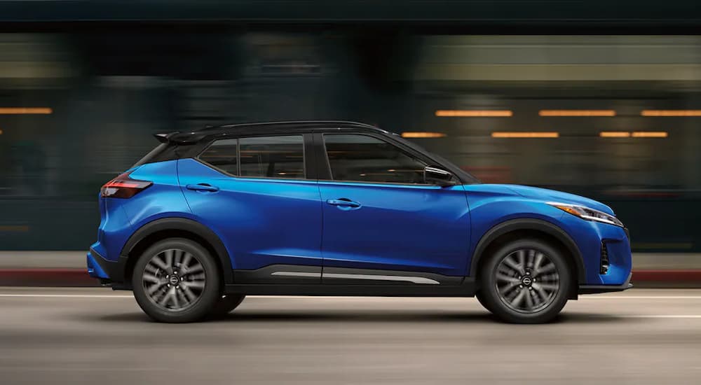 A blue 2024 Nissan Kicks SR driving on a highway after leaving a Nissan dealer.